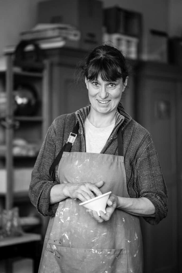 Porträt einer Person in ruhiger Haltung vor einem Atelierhintergrund